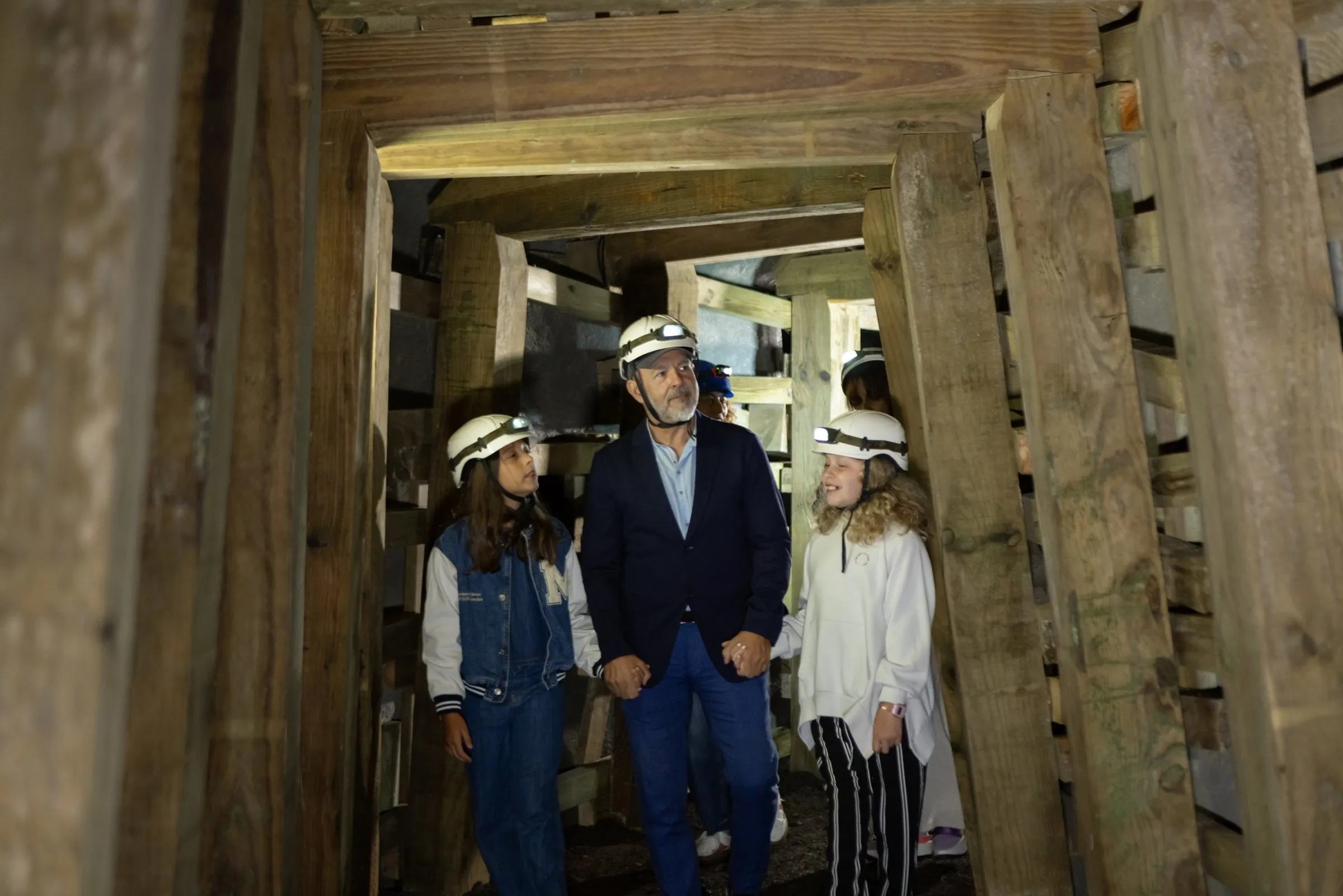 Visitantes con casco recorren una galería de la mina